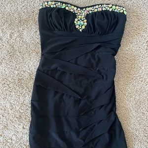 Strapless black dress with gems on the top. Comes slightly above the knee